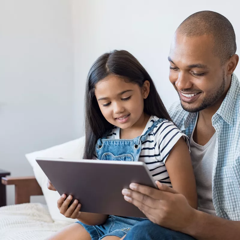 Dad and daughter reading tablet