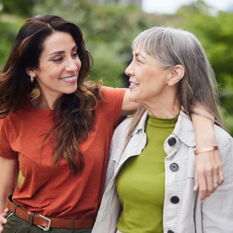 Mother and daughter walking through the garden, talking about their health