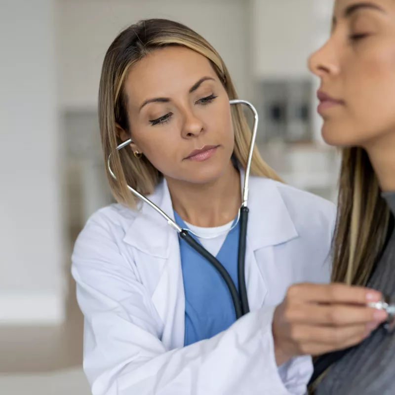 Doctor checking woman's heart